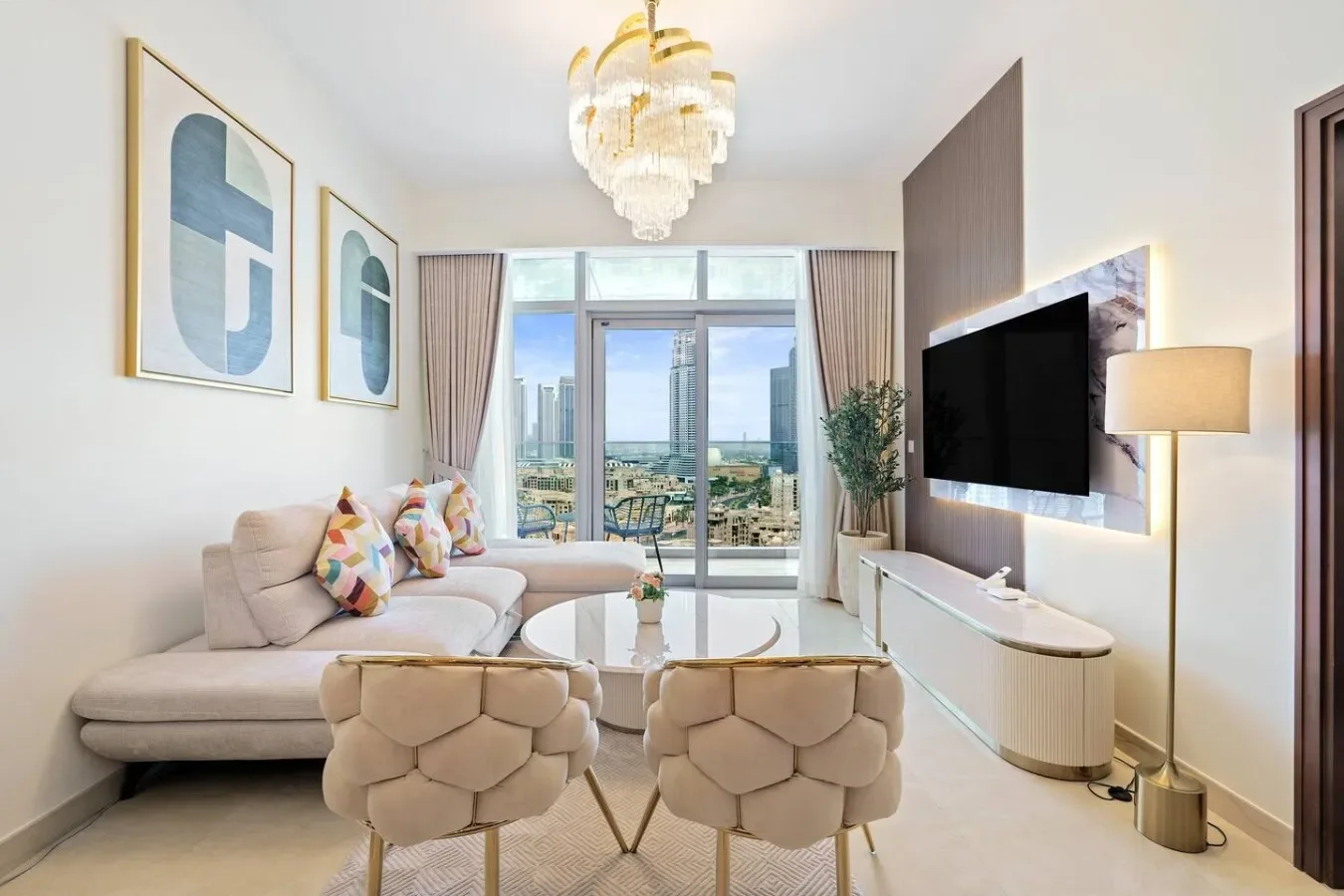 Una sala luminosa con asientos, una mesa de centro y grandes ventanas con vistas a la ciudad.