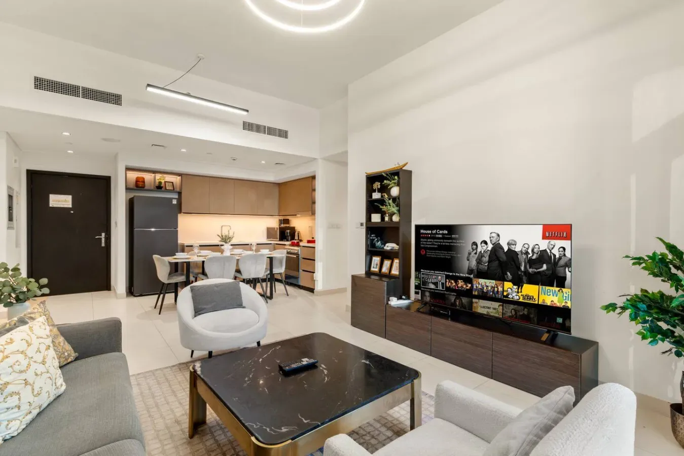 Una sala luminosa con asientos alrededor de una mesa de centro y un televisor.