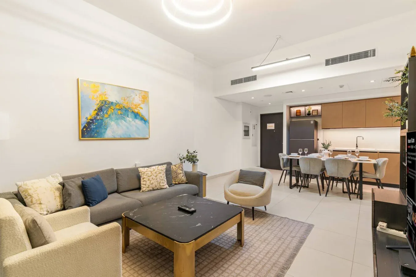 Una luminosa sala de estar y cocina de concepto abierto con mesa de comedor y asientos.