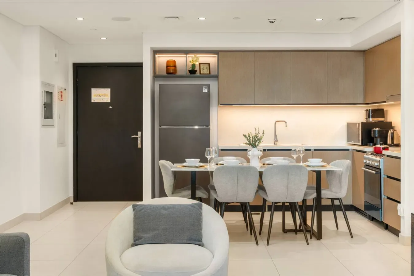 Una cocina moderna y zona de comedor con mesa y asientos.