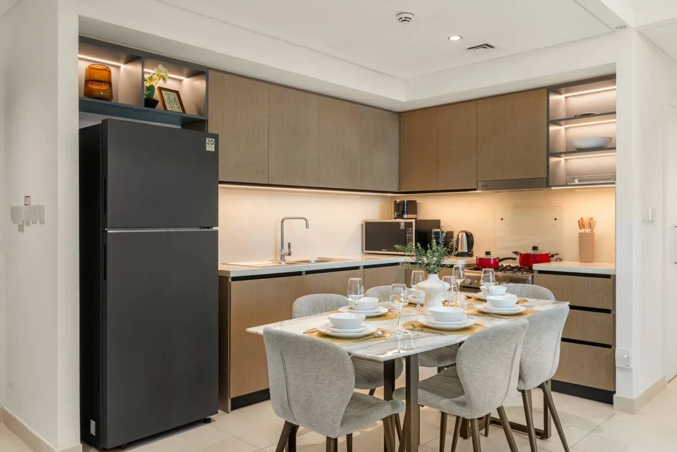 Una cocina moderna y zona de comedor con una mesa puesta con platos.