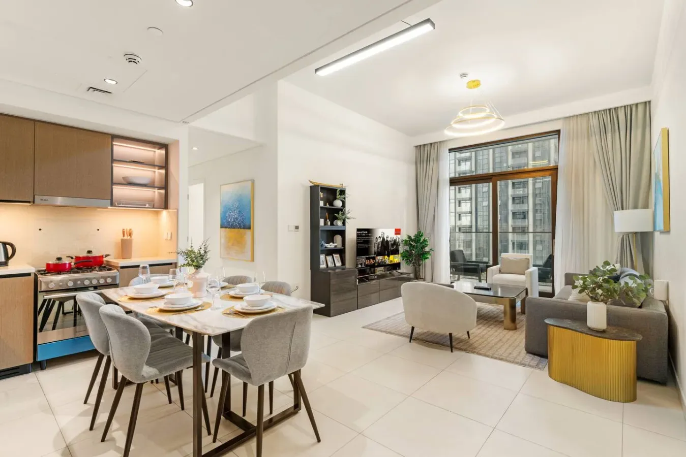 Una luminosa sala de estar y comedor de planta abierta, con una mesa y grandes ventanas.