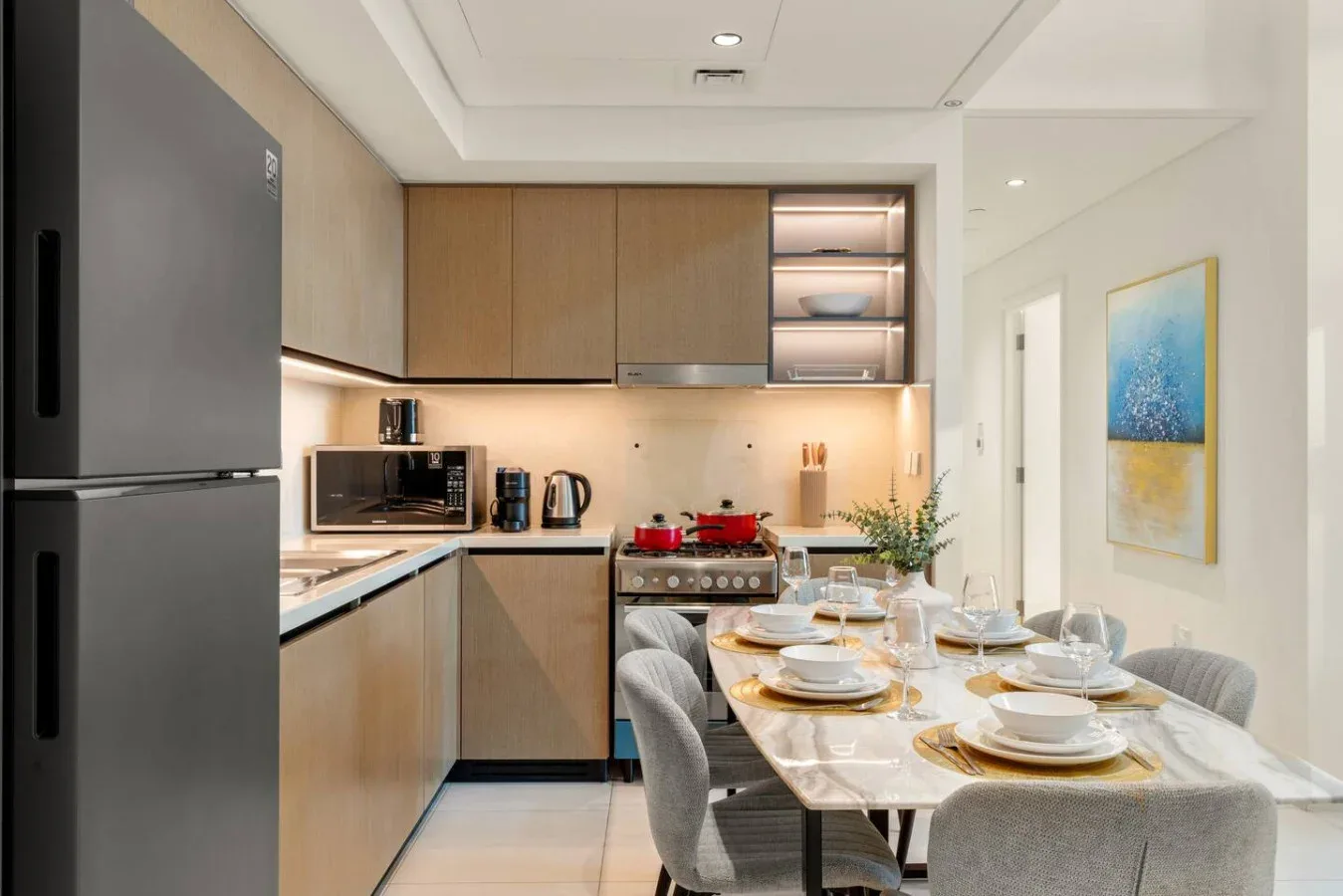Cocina y comedor modernos con una mesa puesta con platos.