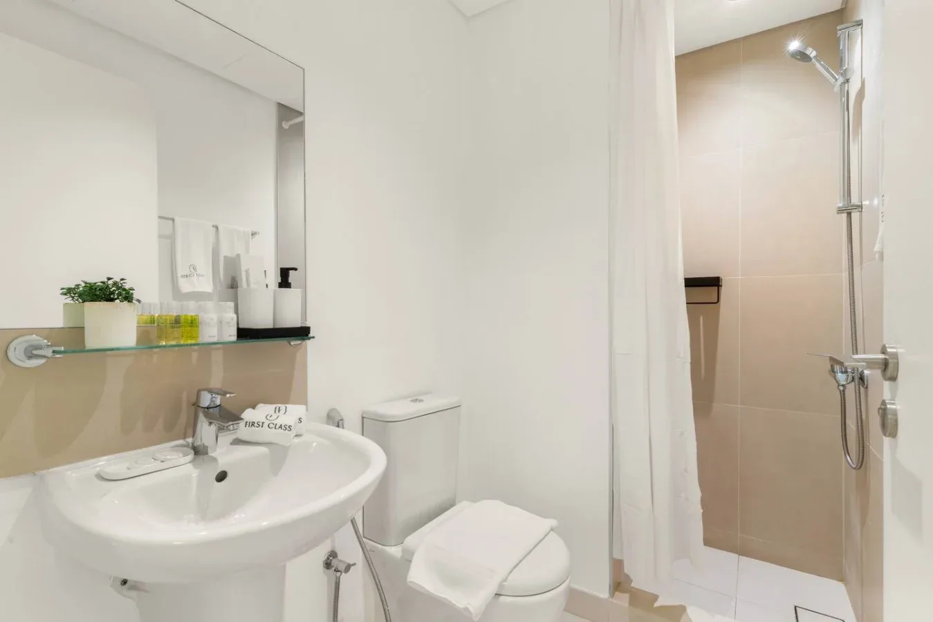 Un baño con lavabo, inodoro y ducha detrás de una cortina.