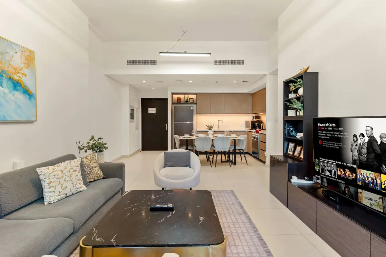 Una sala luminosa se abre a un comedor y una cocina compacta.