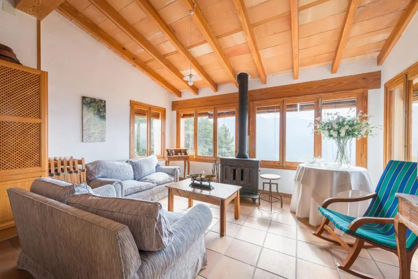 A bright living room with seating, a coffee table, and large windows.