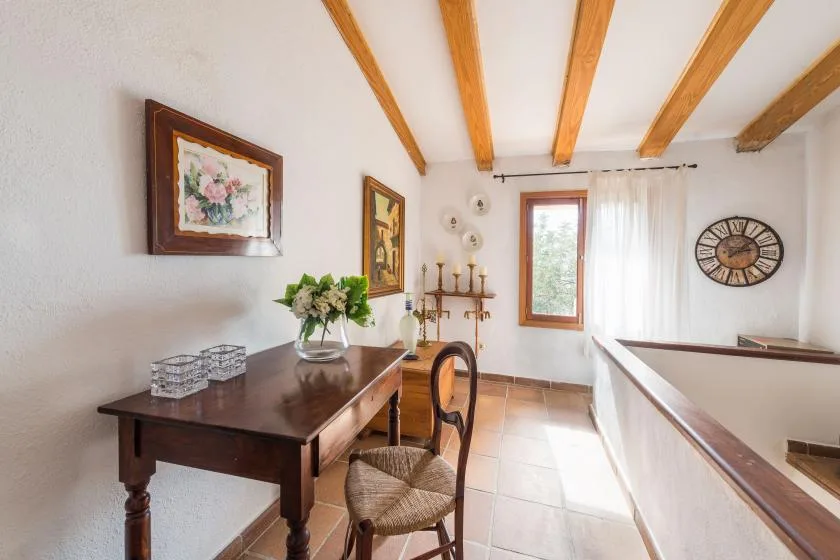 A bright upstairs landing with a dark wooden table and a window.