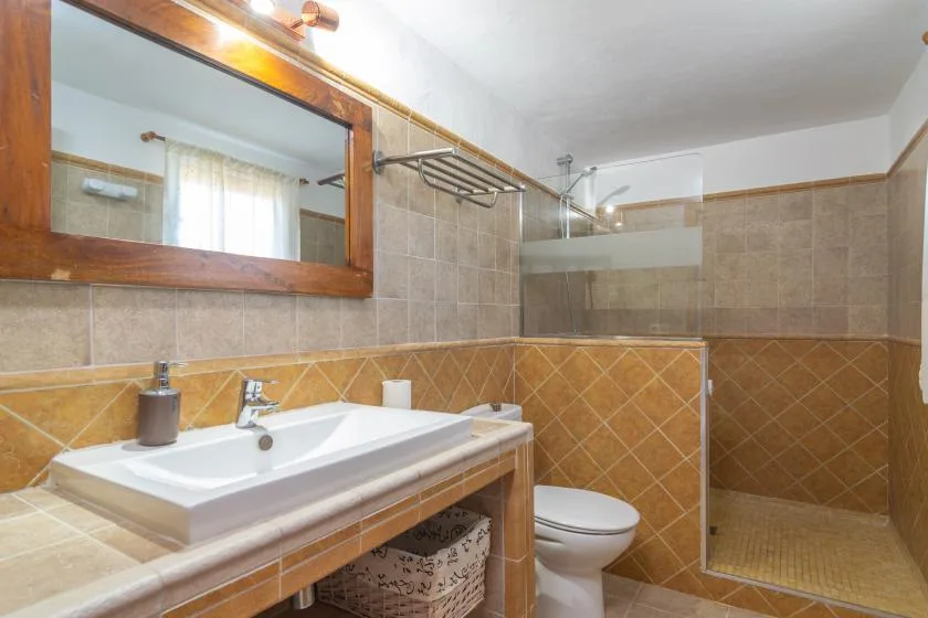 A tiled bathroom with a sink, toilet, and shower.