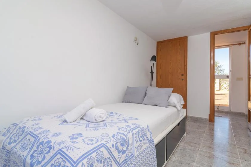 A bedroom with a bed covered in blue-and-white patterned bedding.