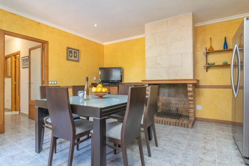 A dining area with a table, chairs, and a fireplace.