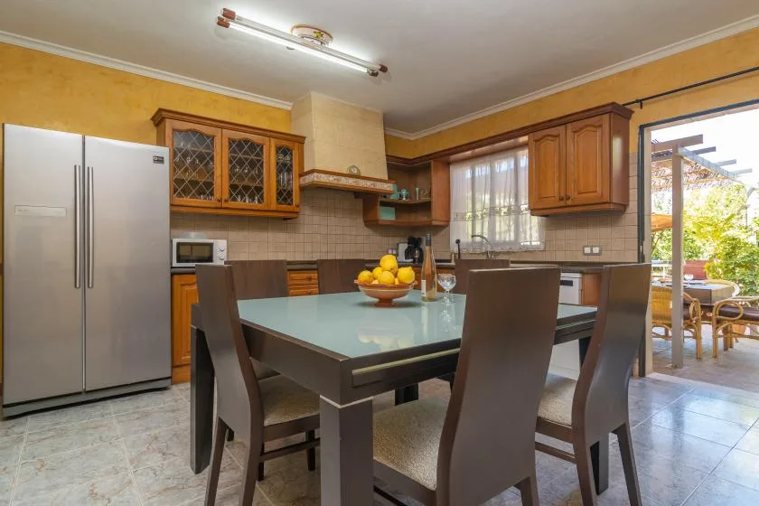 A dining area with a table and chairs beside a kitchen.