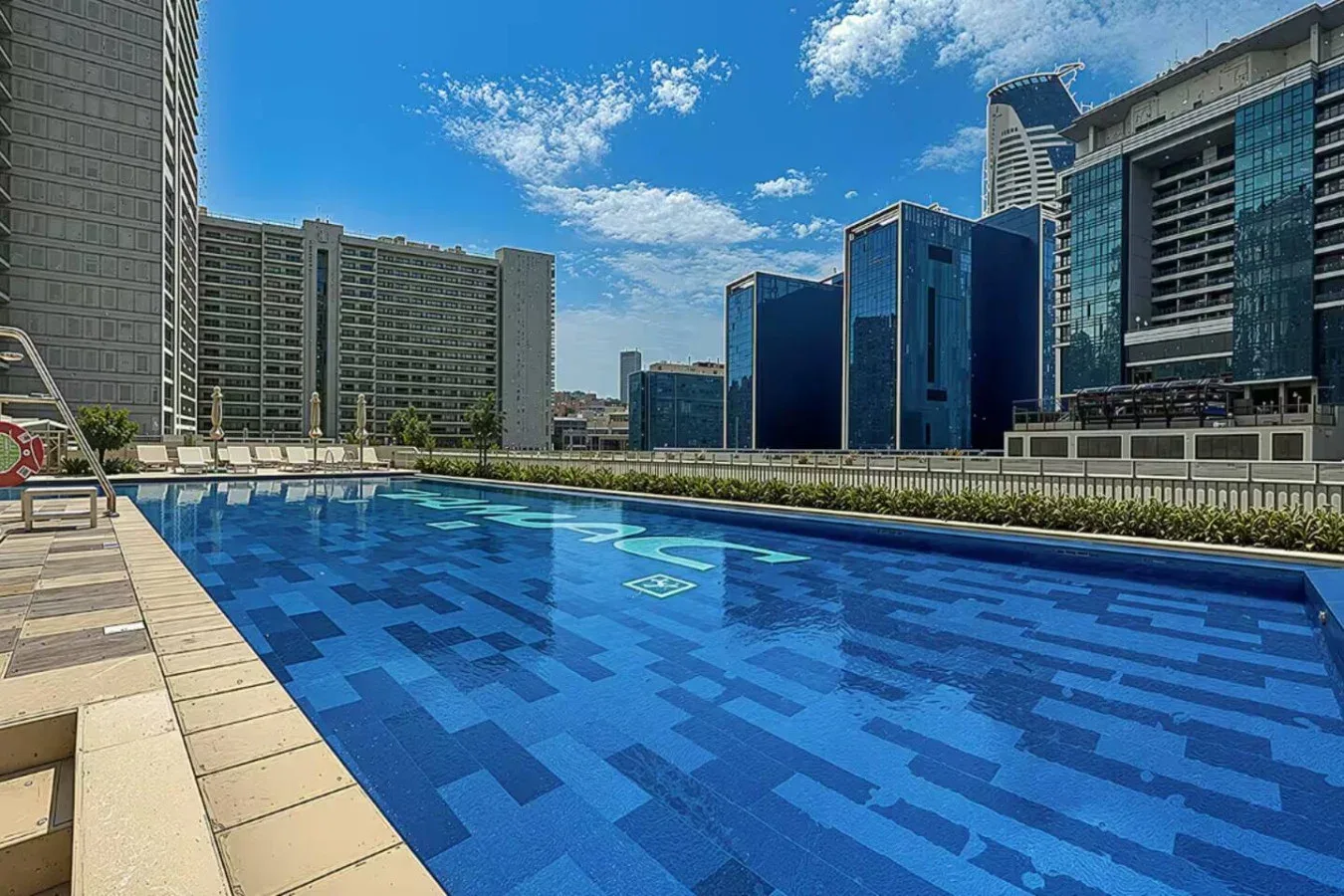 Una piscina al aire libre con agua de azulejos azules y edificios altos al fondo.