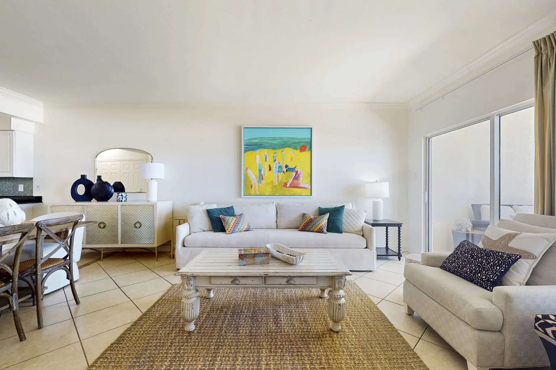 A bright living room with seating around a coffee table and large windows.