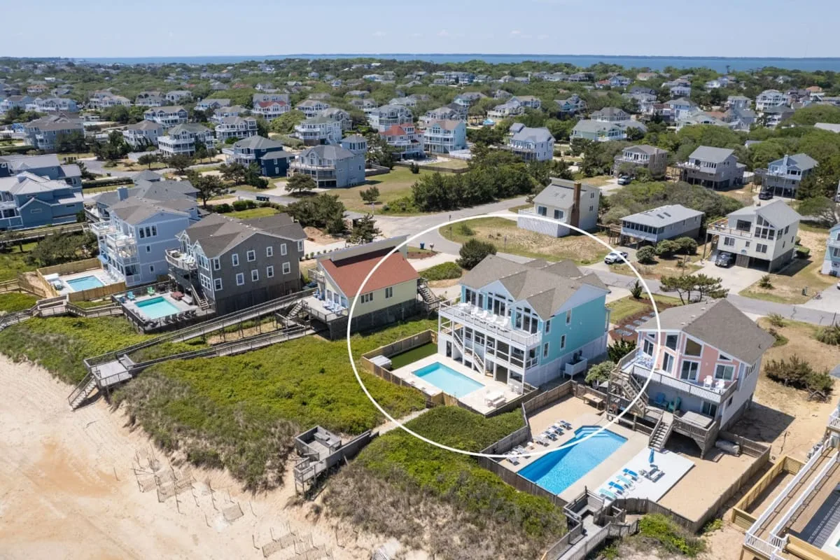 An aerial view of coastal homes, including a house with a swimming pool.