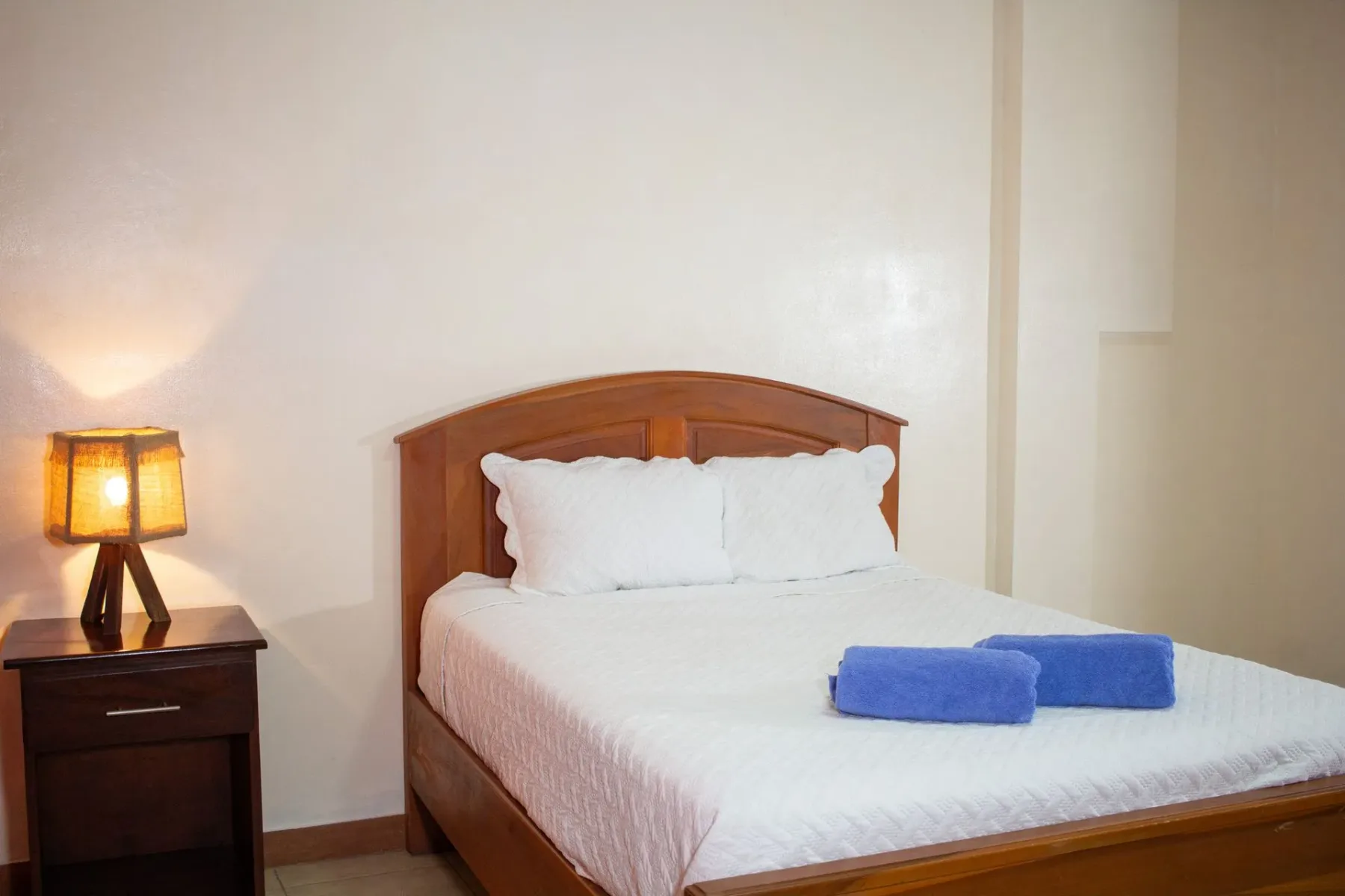 Dormitorio con cama de madera y mesa de noche