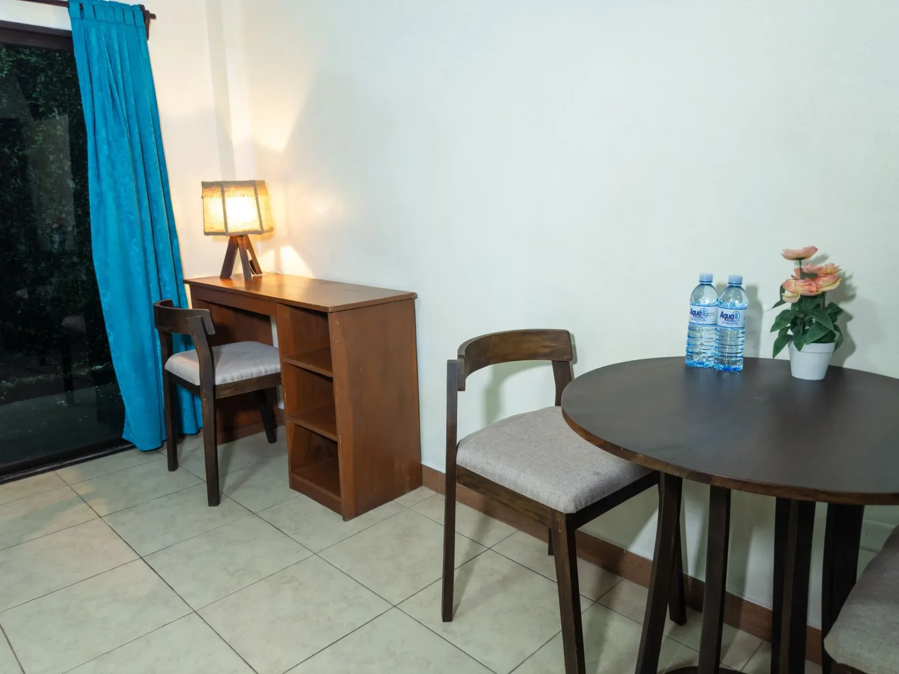 Habitación con escritorio, sillas y cortina azul