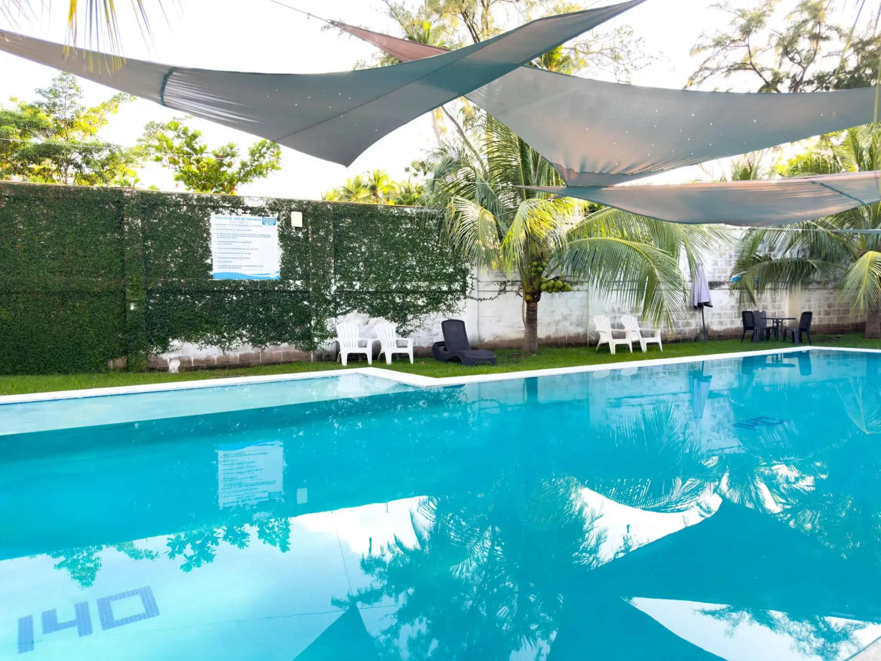 Piscina con tumbonas y velas de sombra