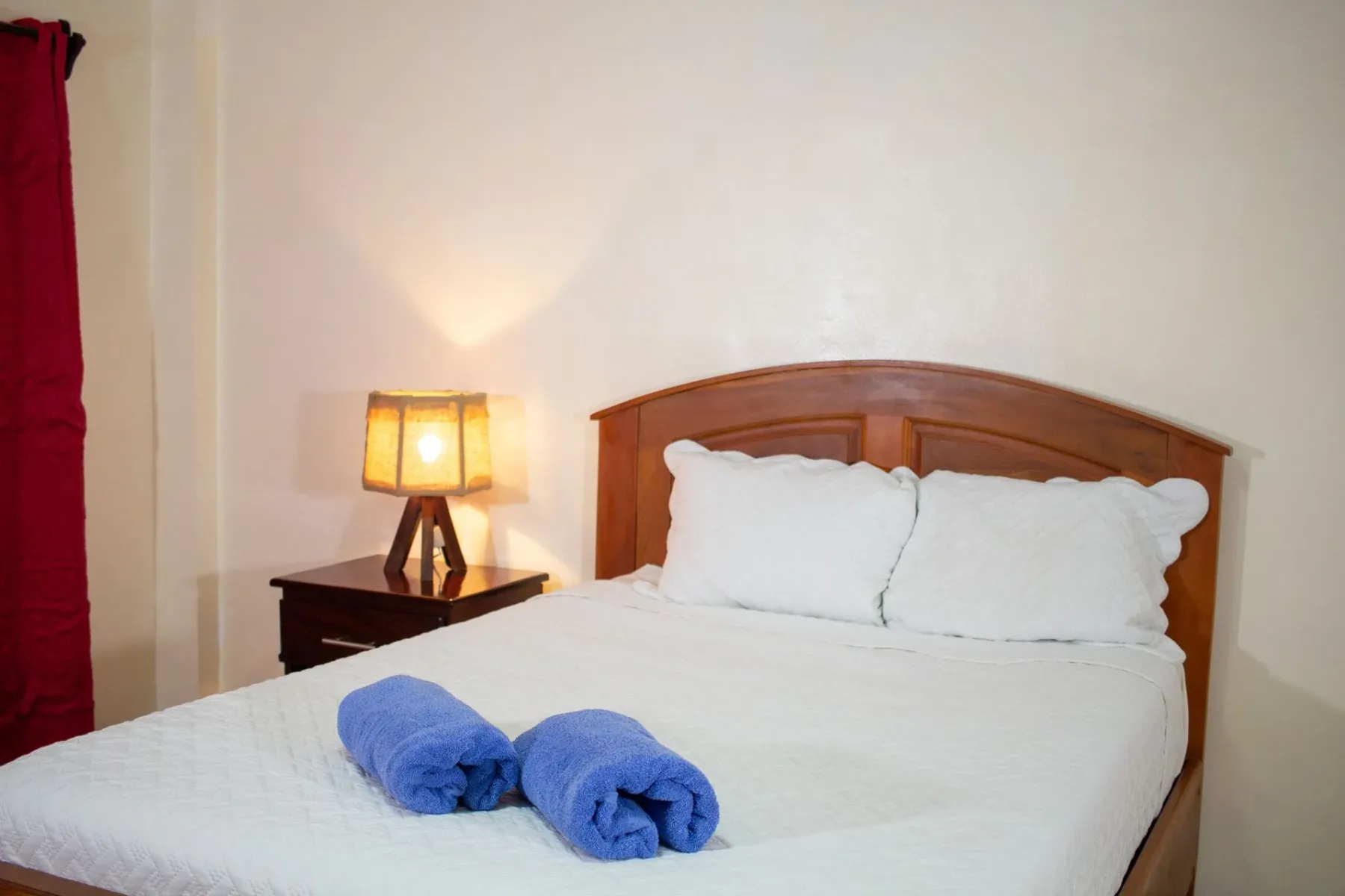 Dormitorio con cama, mesa de noche y lámpara