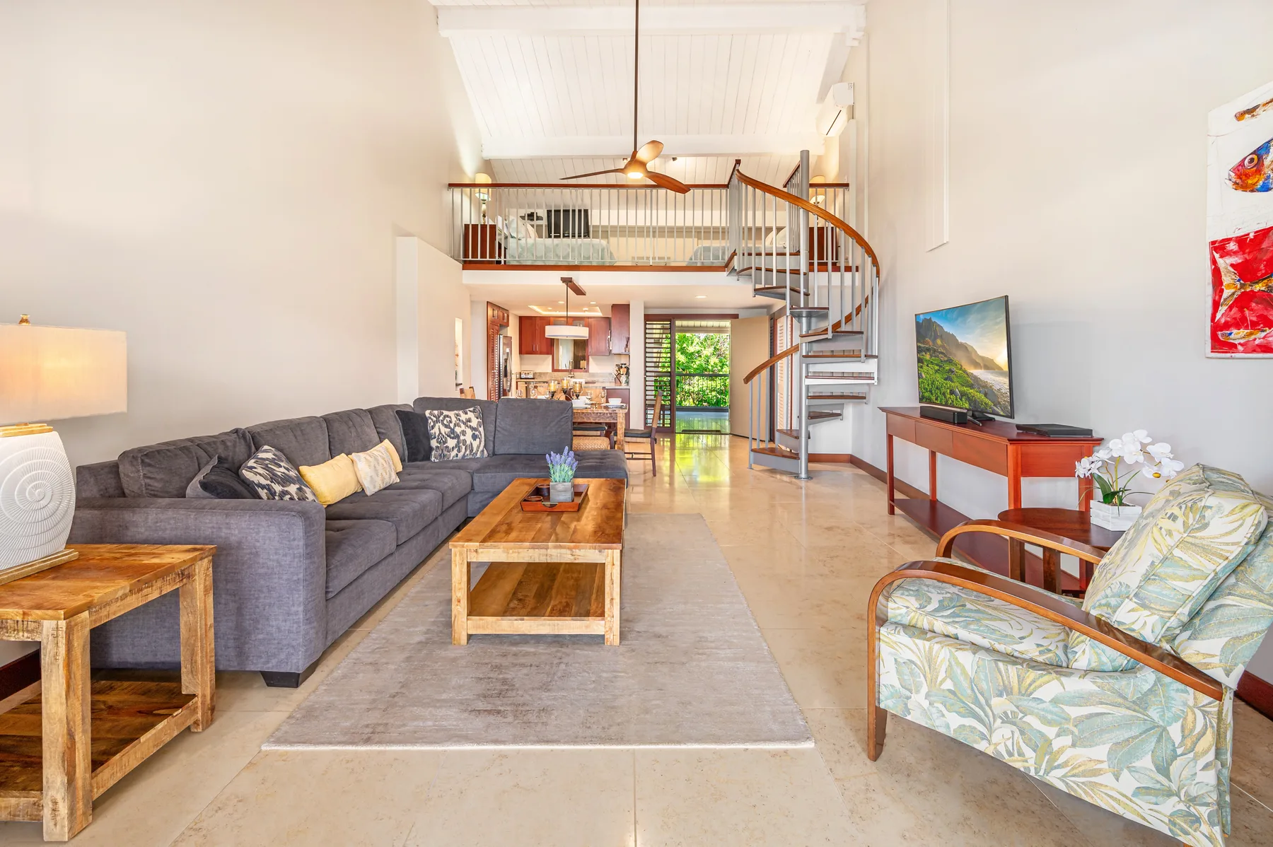 A living room with seating, a coffee table, and a spiral staircase.