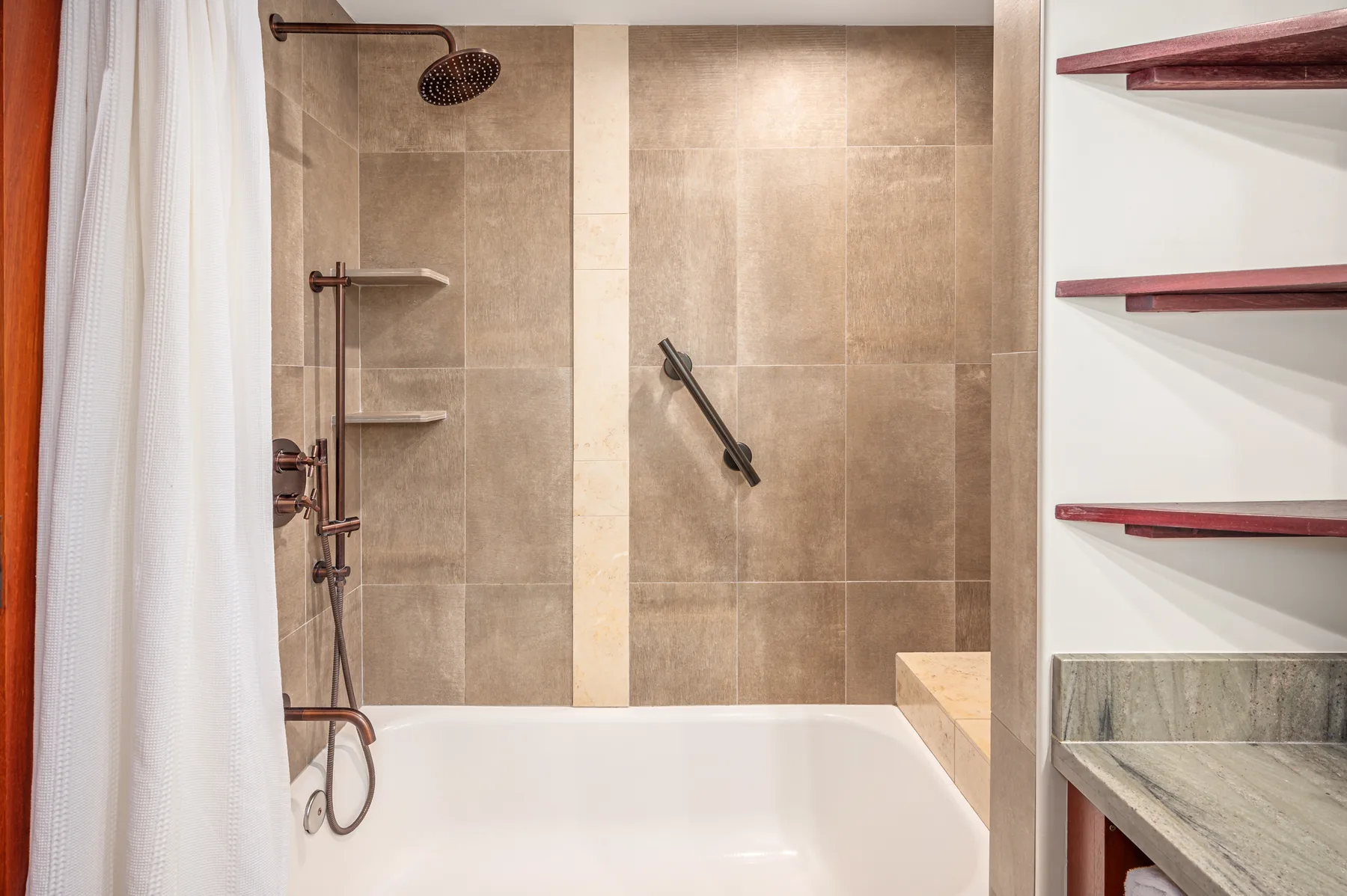 A tiled bathroom with a bathtub, shower fixtures, and a white curtain.