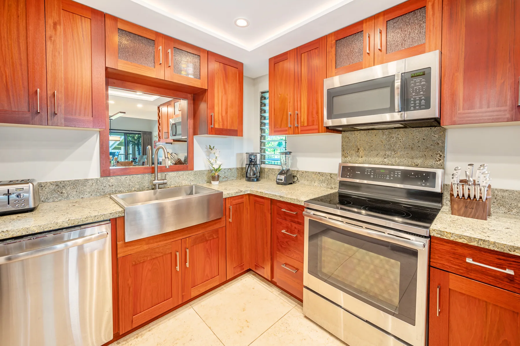 A bright kitchen with wooden cabinets, a sink, and stainless steel appliances.