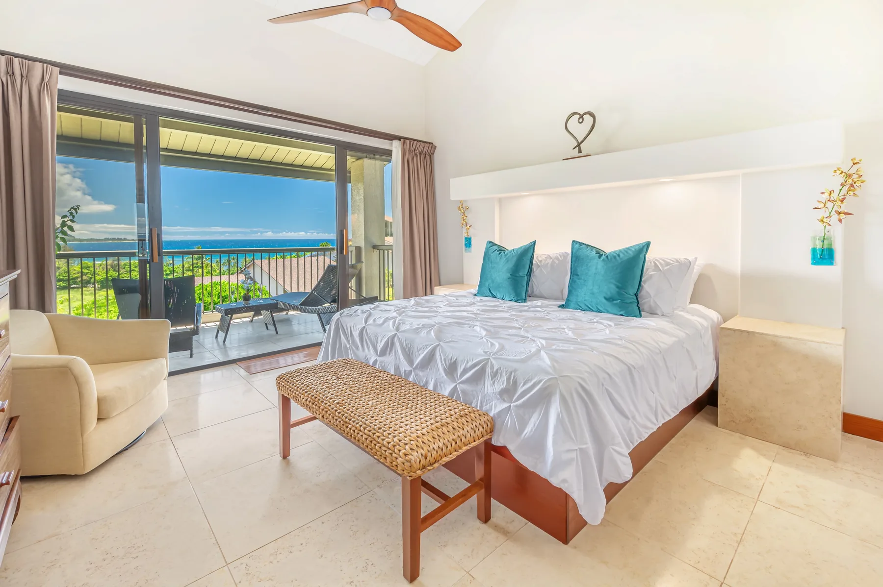 A bright bedroom with a bed and sliding glass doors opening onto a balcony.