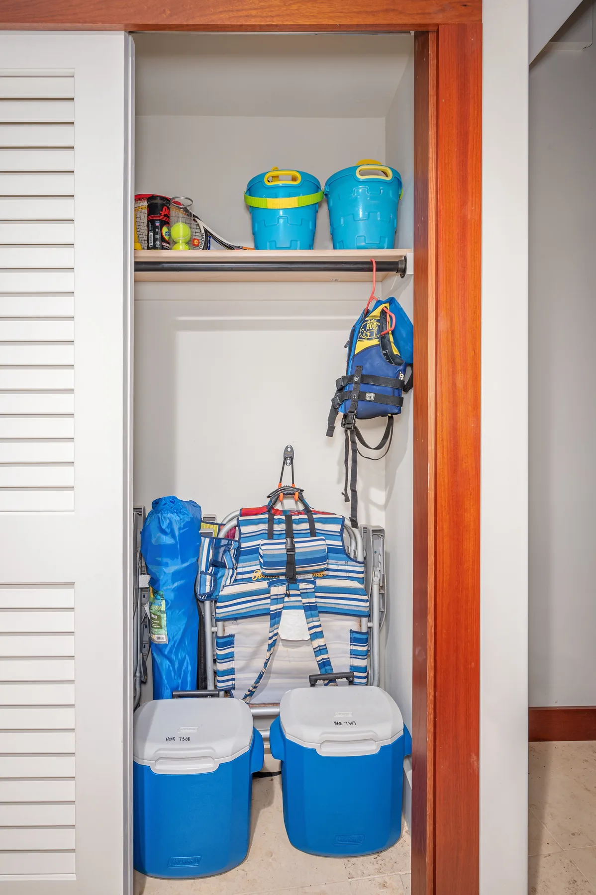 An open storage closet holds coolers, bags, and other gear.