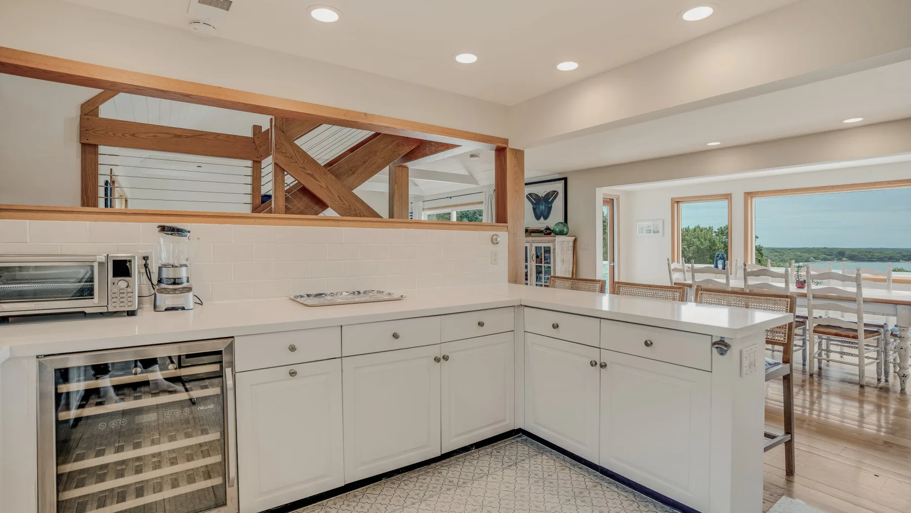 A bright kitchen with white cabinets and a long countertop.