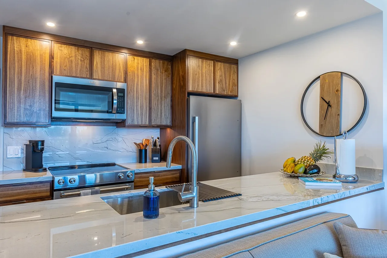 Una cocina moderna con gabinetes de madera, electrodomésticos de acero inoxidable y una amplia isla.