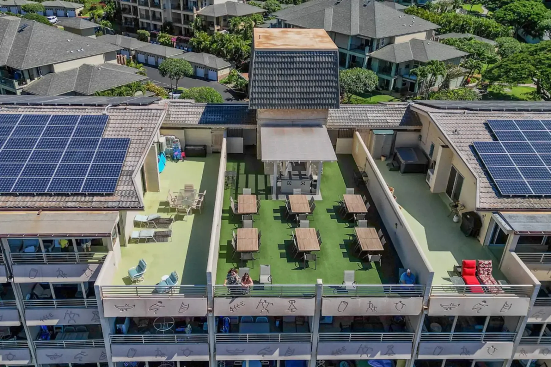 Vista elevada de una terraza al aire libre con mesas y paneles solares.