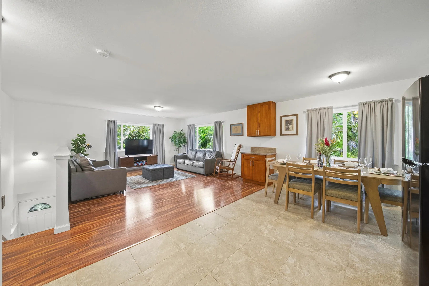 An open-plan living and dining room with seating and a wooden dining table.