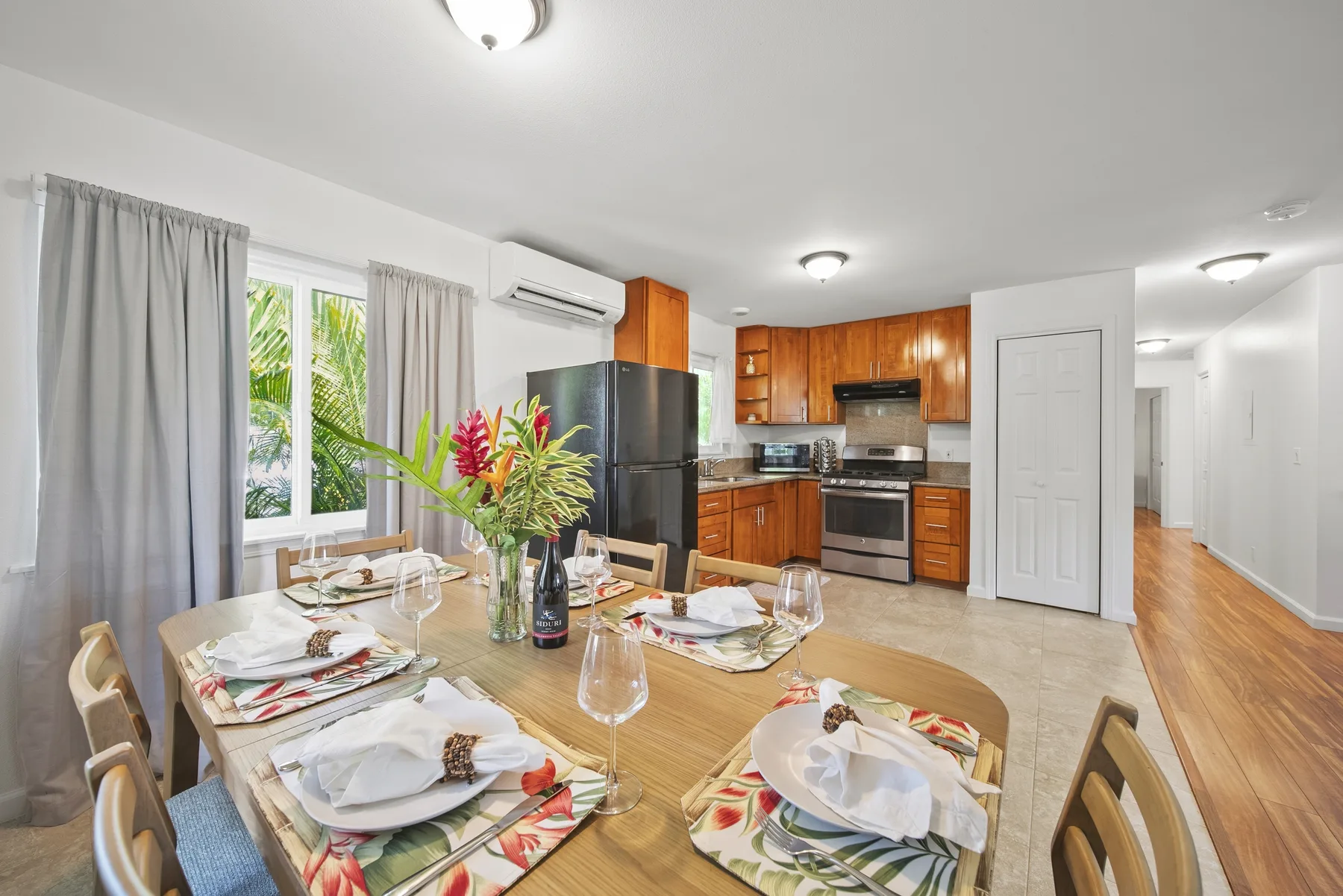 A dining area with a set table beside an open kitchen.