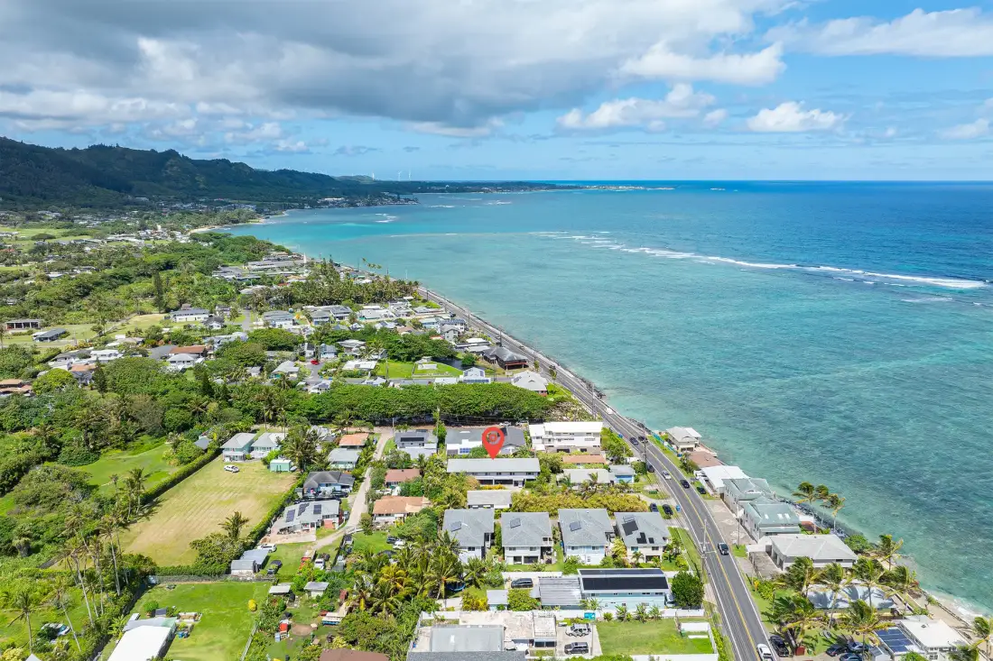 An aerial view shows a coastal neighborhood beside the ocean.