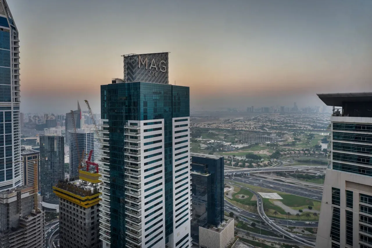 City skyline with modern high-rise buildings and roads visible in the distance.