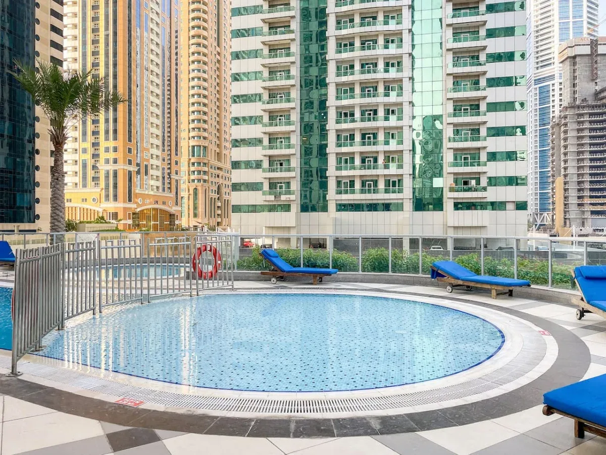 A circular outdoor swimming pool sits among tall residential buildings.