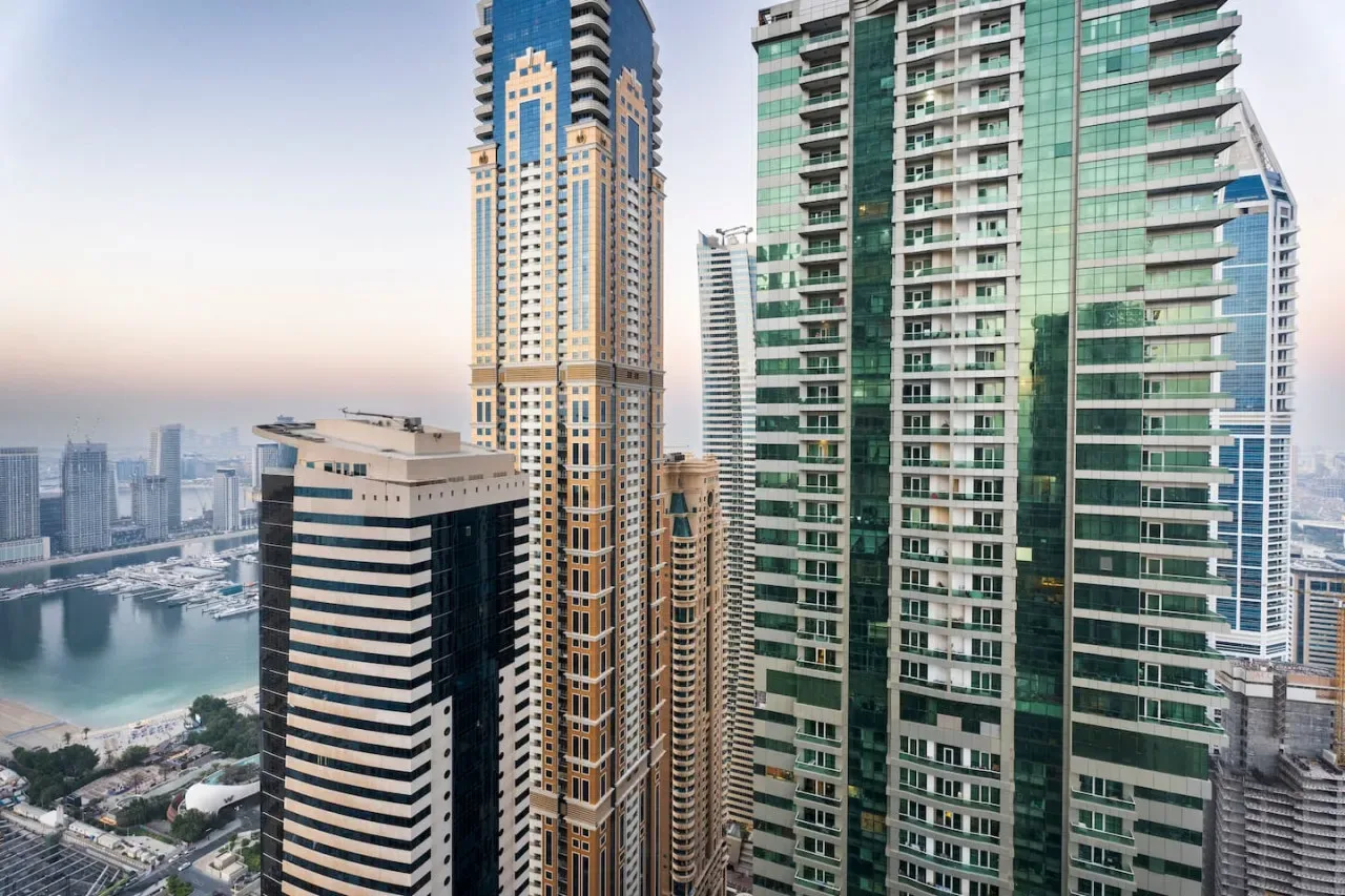 City skyline with tall modern buildings overlooking a waterfront.