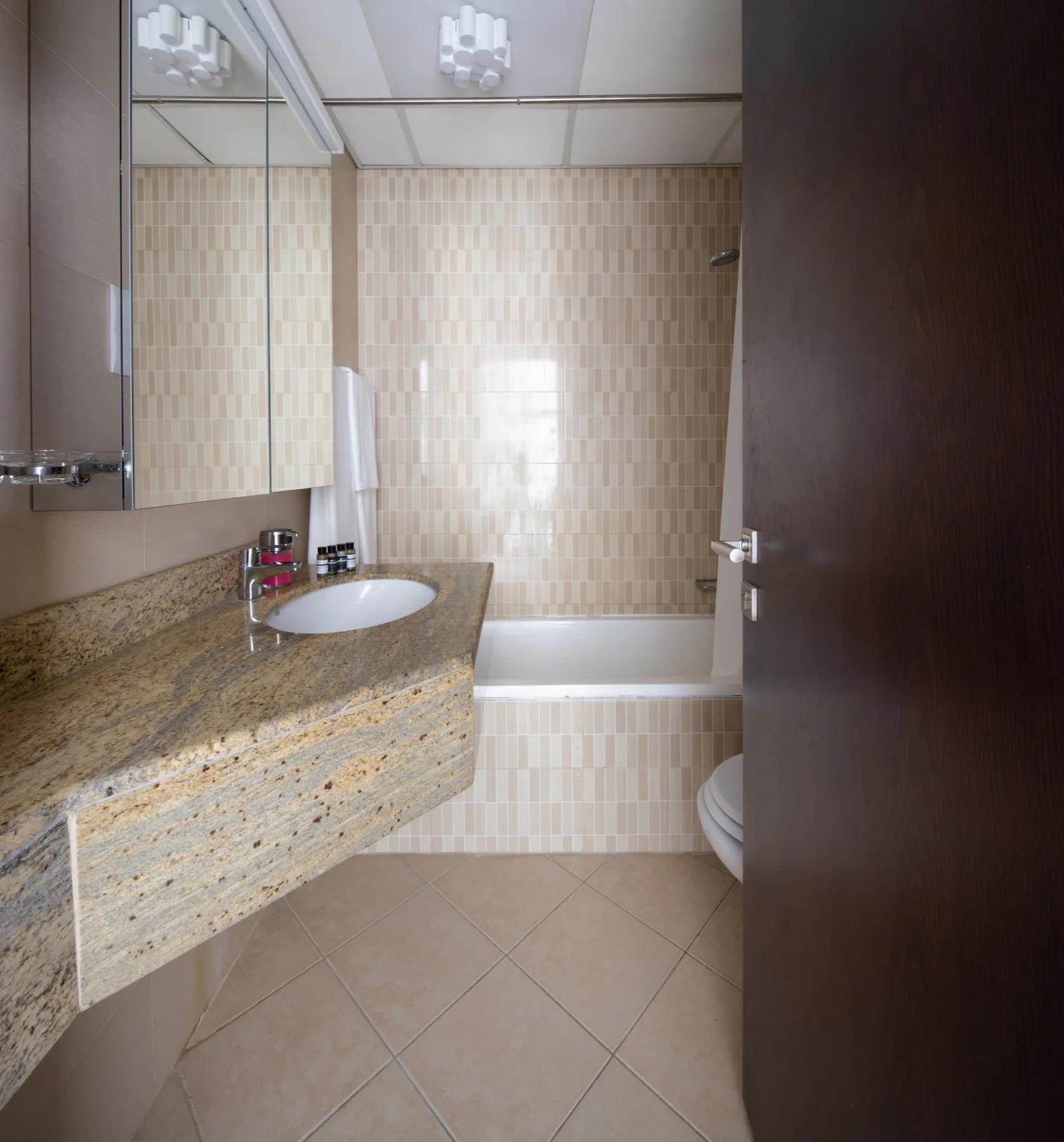 Un baño alicatado con lavabo, tocador y bañera.