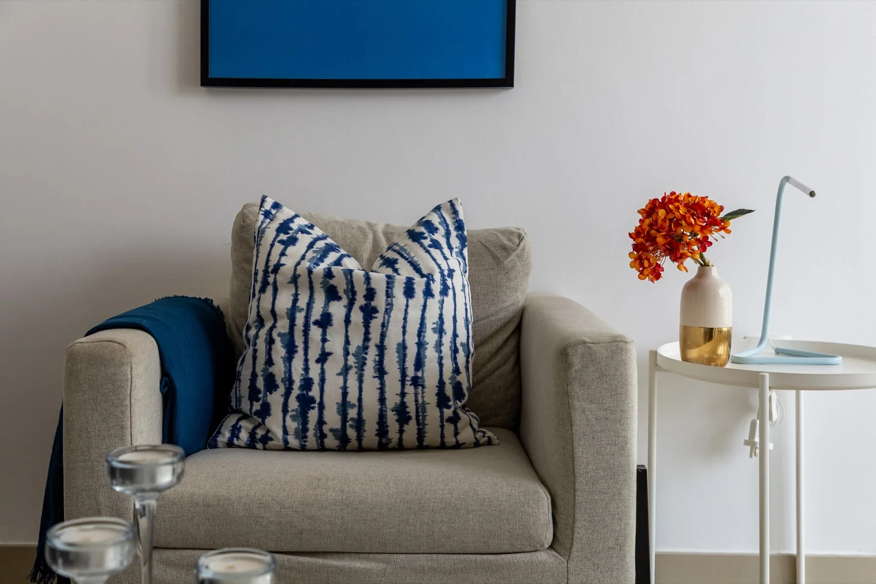 Una zona de estar en una sala con un cojín estampado junto a una mesa pequeña.