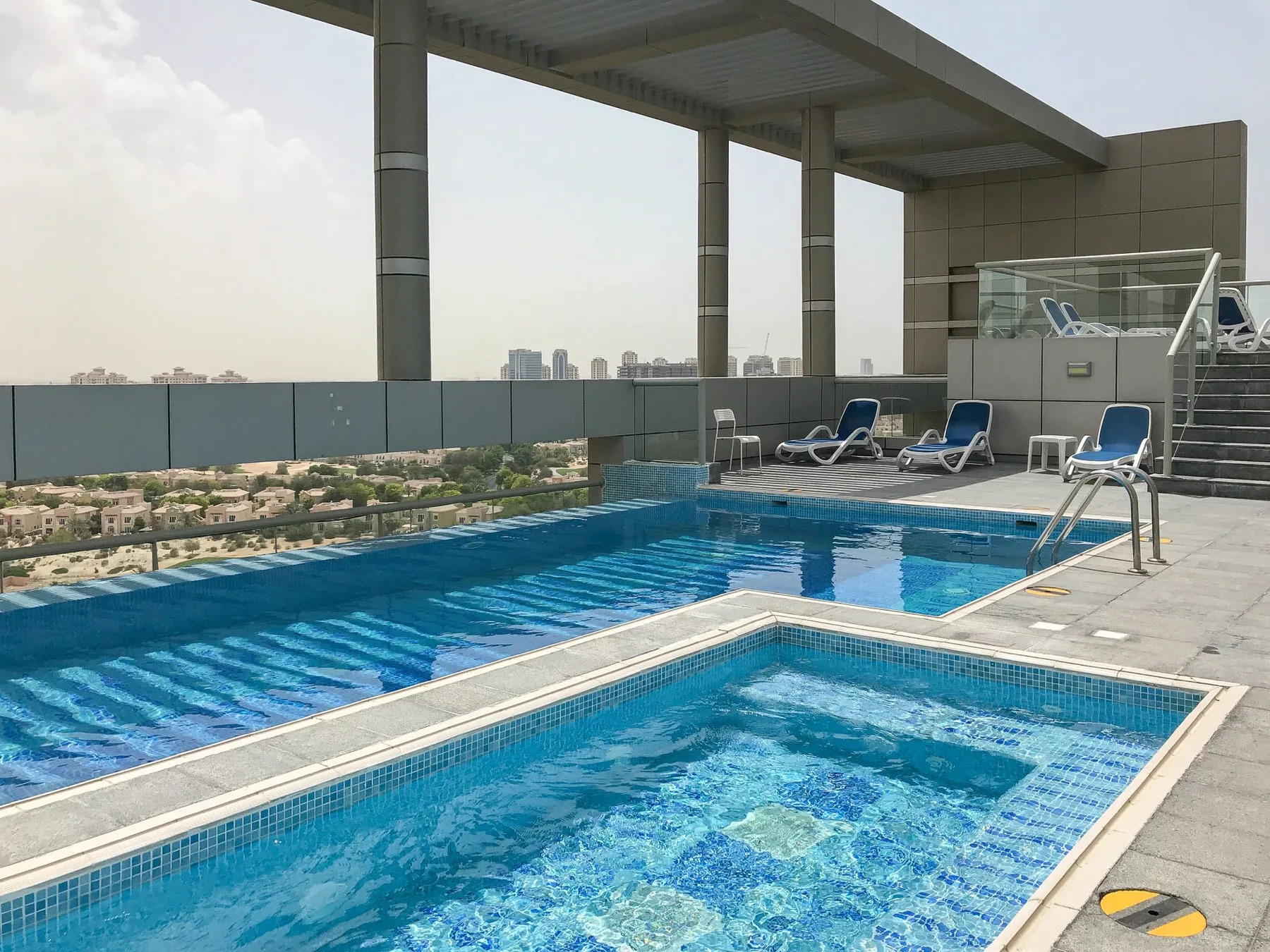 Una piscina en la azotea y otra más pequeña contigua están junto a asientos de descanso.