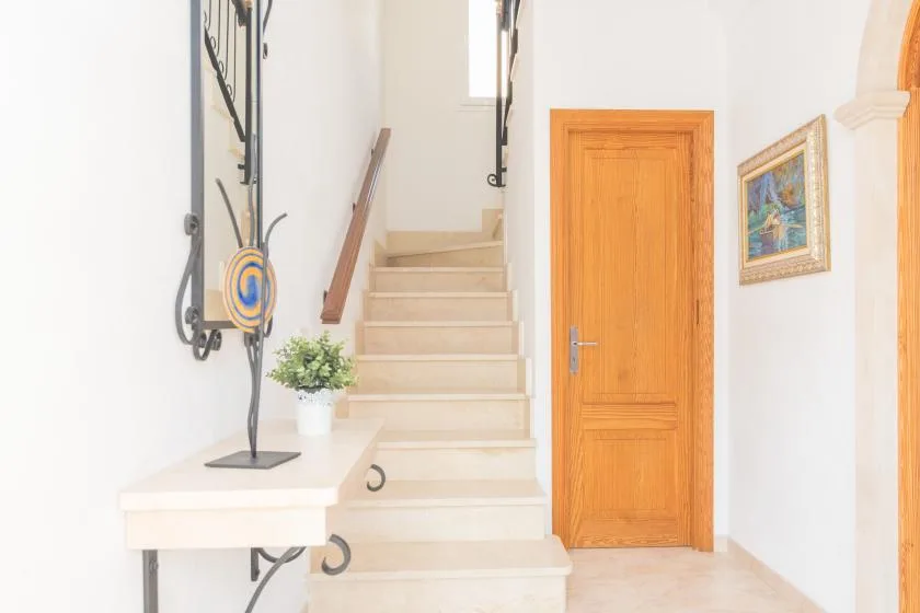 A bright entryway with a staircase and a wooden door.