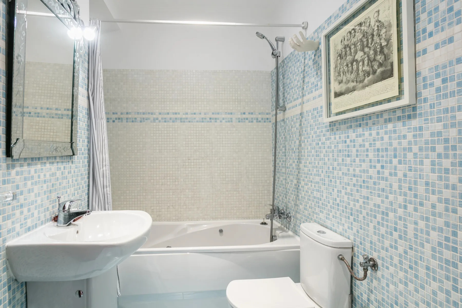 A tiled bathroom with a bathtub, sink, and toilet.