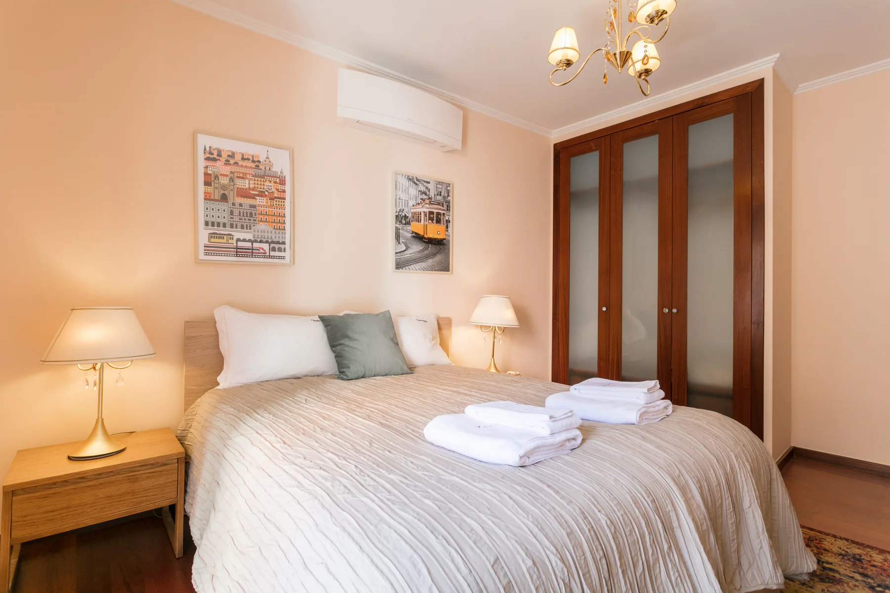 A bedroom with a double bed, bedside tables, and a wardrobe.