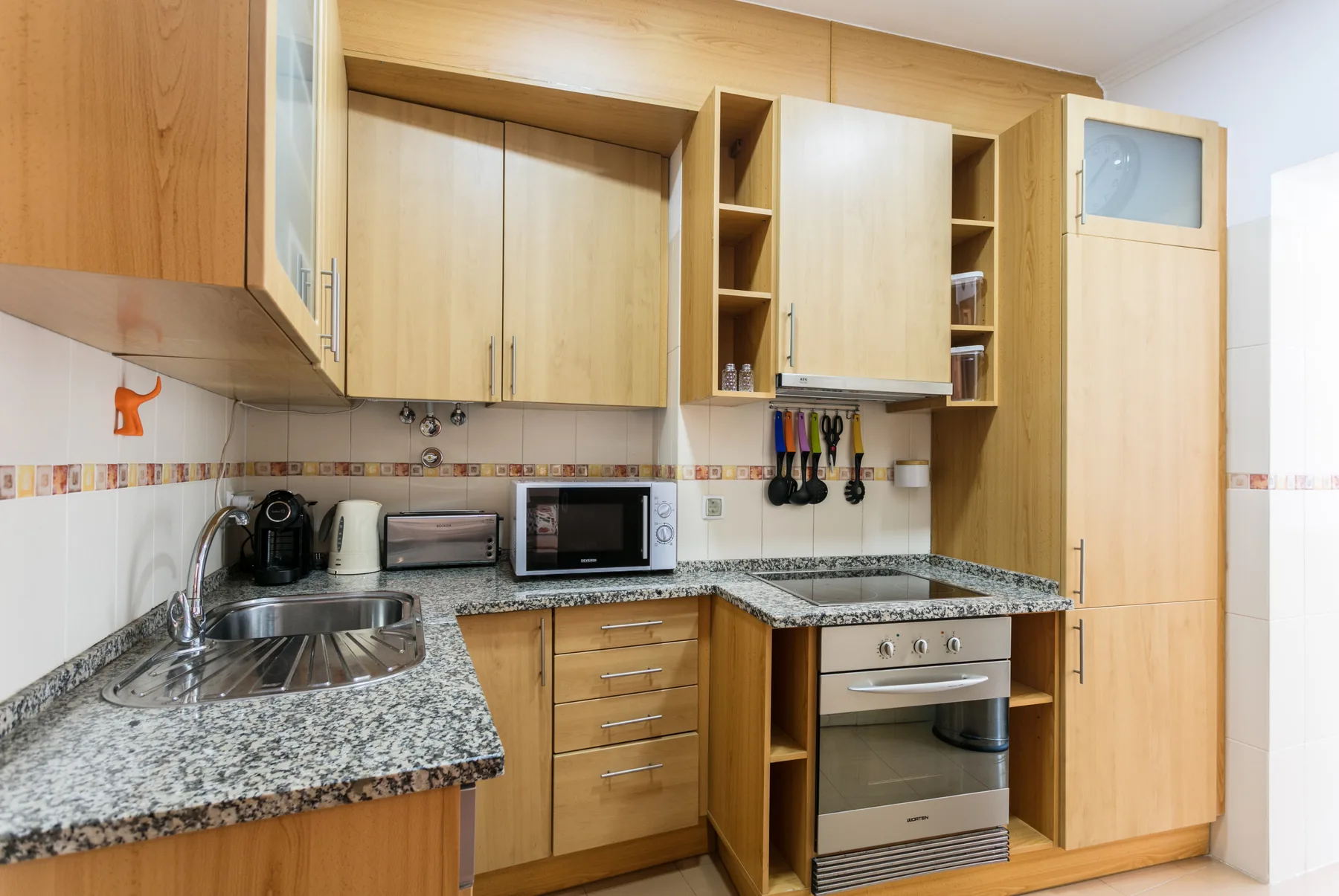 A fitted kitchen with wooden cabinets, countertops, a sink, and an oven.