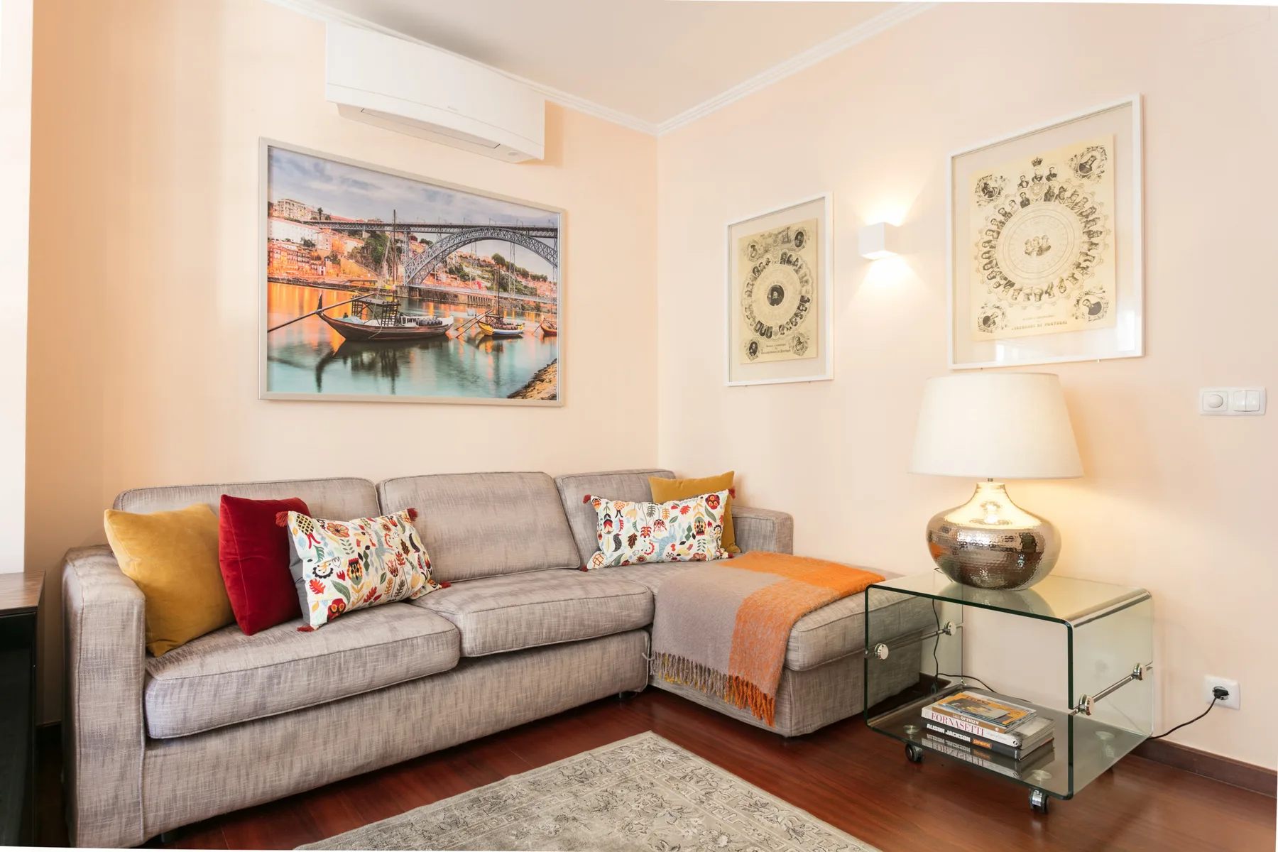 A living room with a sectional seating area and framed wall art.