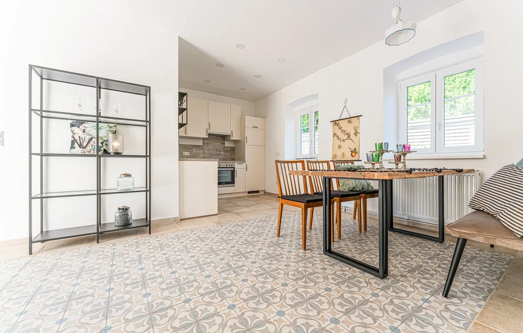 Un comedor luminoso con una mesa y sillas junto a una cocina abierta.