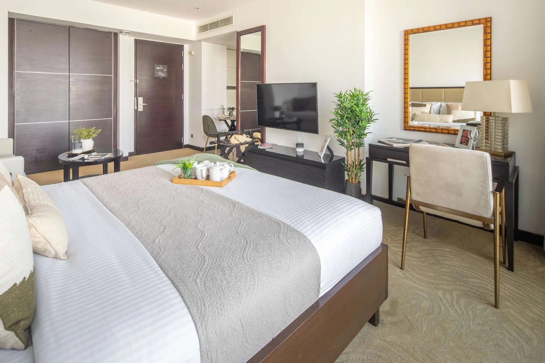 Un dormitorio con una cama grande, televisor y escritorio.