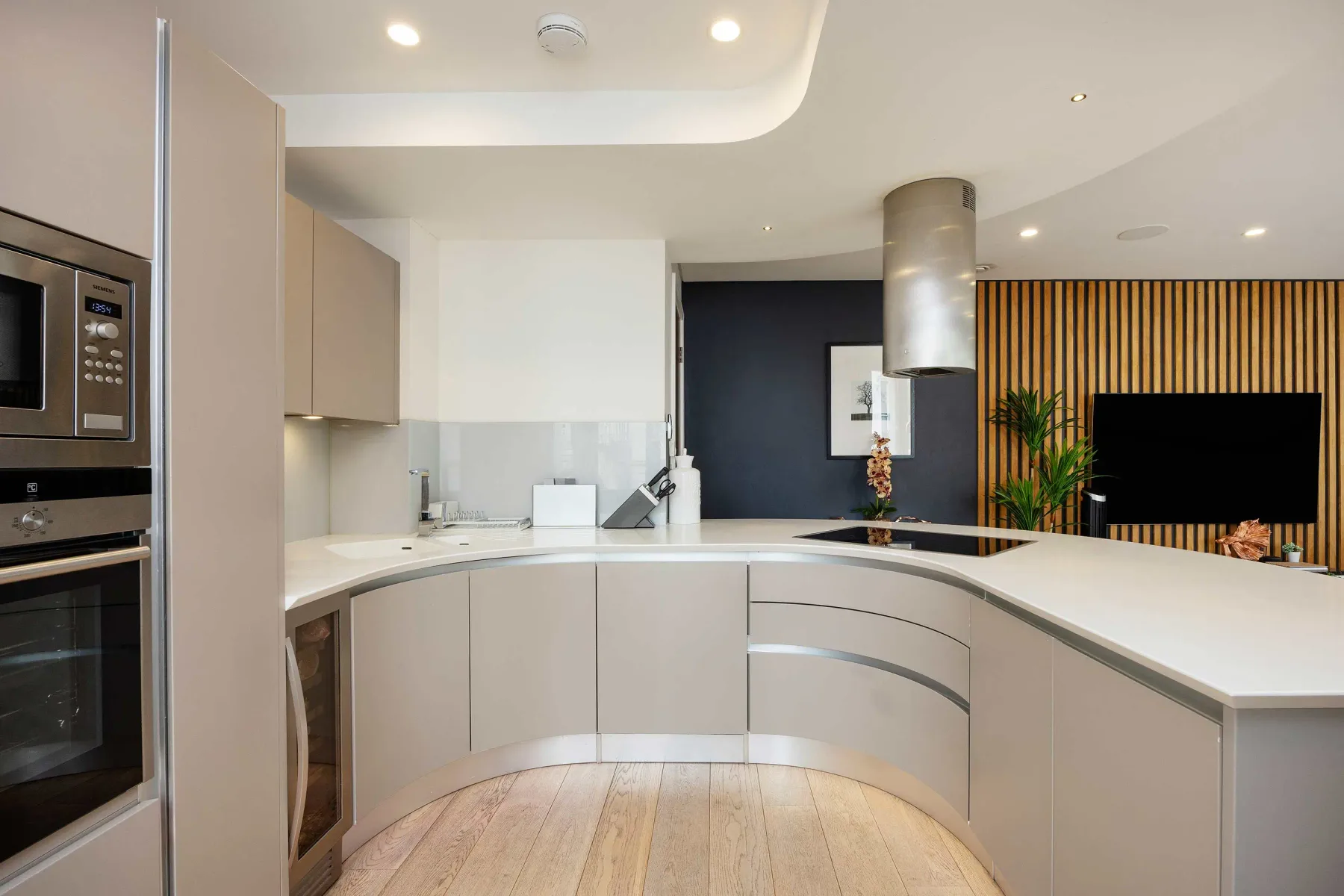 A modern kitchen with curved countertops and a cooking island.
