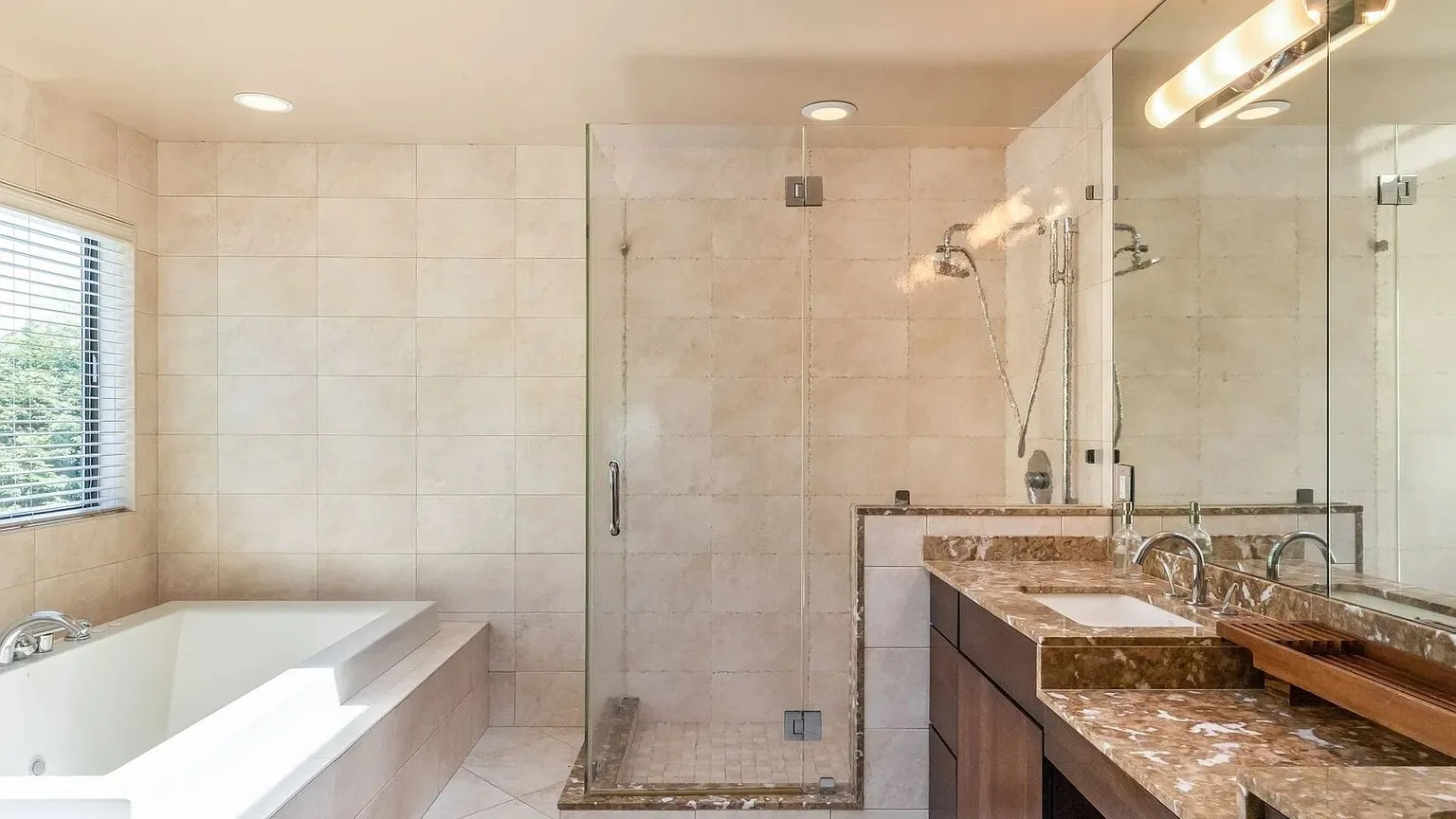 Baño alicatado con bañera, ducha y un tocador alargado.