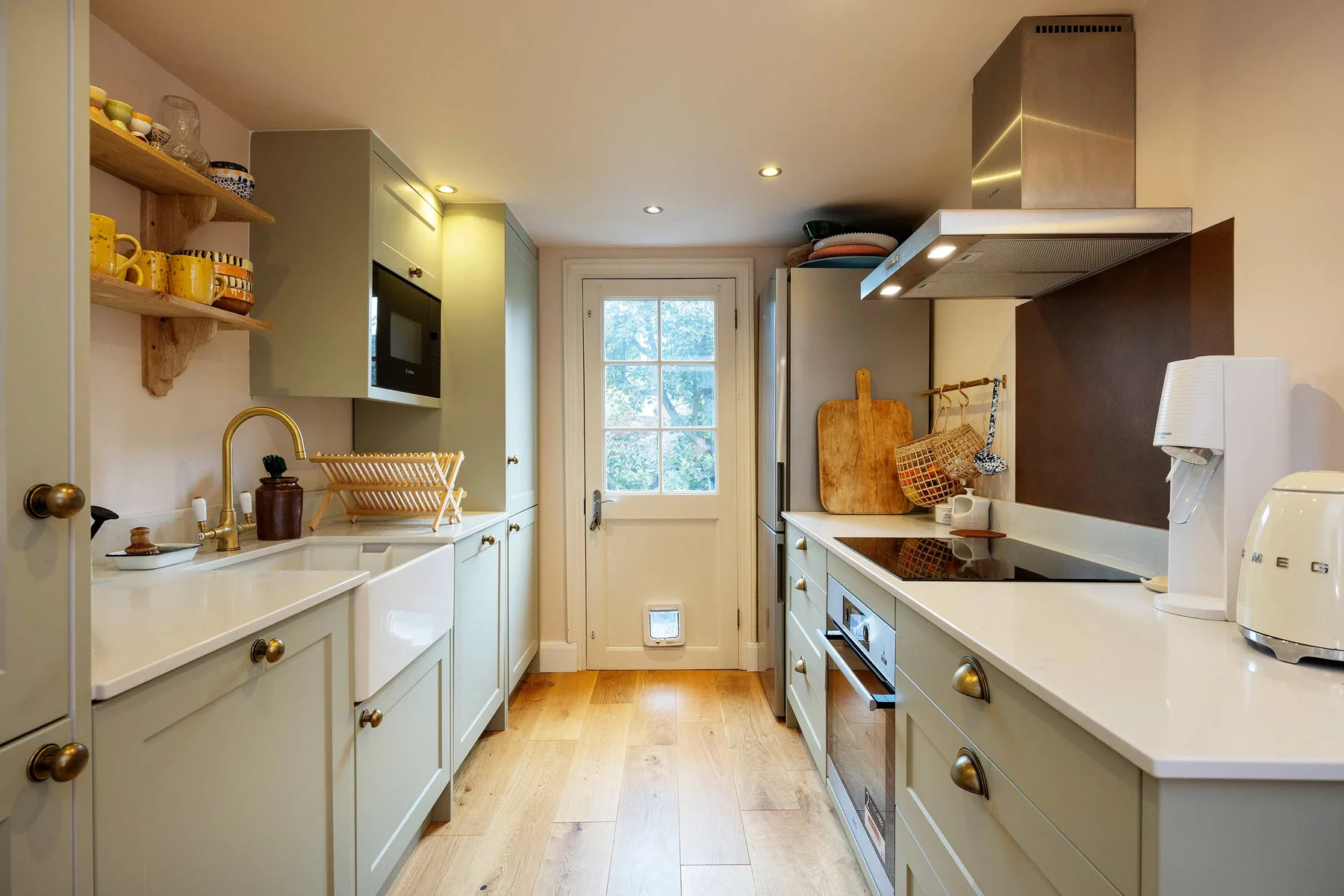 A narrow kitchen with counters and cabinets on both sides of a central aisle.