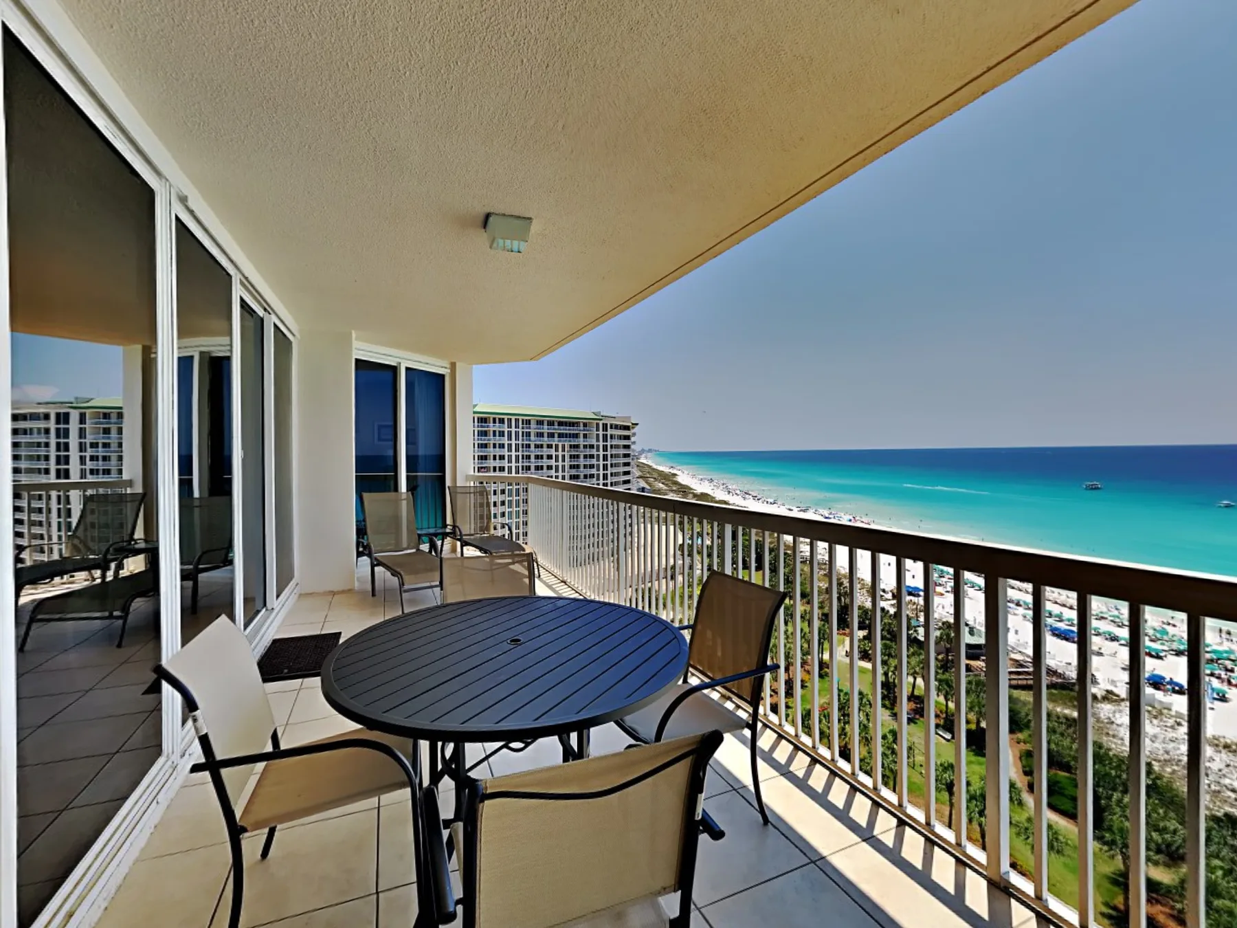 A balcony seating area overlooks the ocean and shoreline.